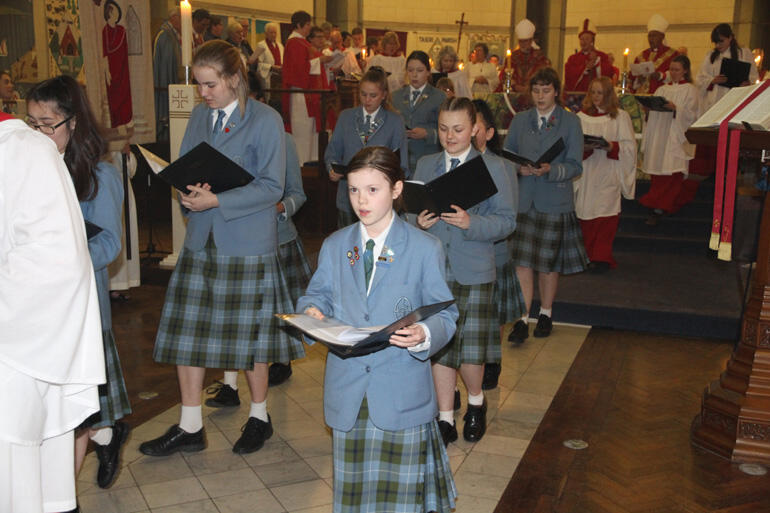 Singers from St Hilda's Collegiate process out before their new bishop. Singers from St Hilda's Collegiate process out before their new bishop.