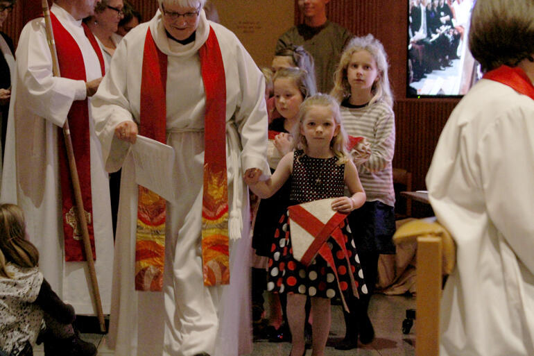 Rev Alison Camplin leads Bishop Eleanor's god daughter Zoe Moss to present the bishop's new mitre.