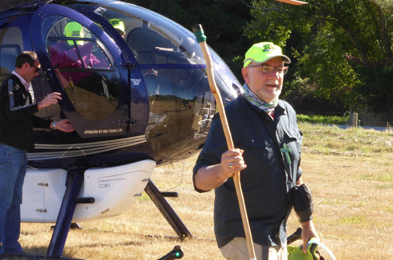 Down to earth again: Bishop Kelvin emerges from the helicopter at Wanaka. Down to earth again: Bishop Kelvin emerges from the helicopter at Wanaka.