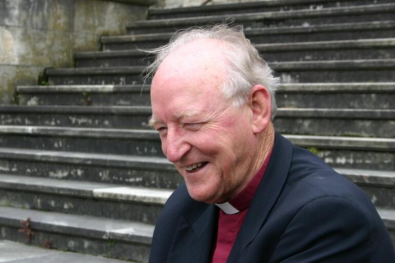 Bishop George on the steps of his cathedral in Dunedin.