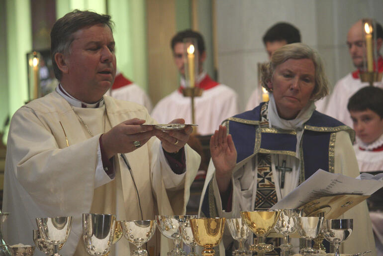 Archbishop David Moxon celebrates as Bishop Victoria looks on.