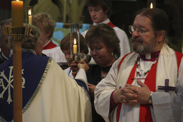 Bishop Mark MacDonald (from Alaska) receives communion from Bishop Victoria.