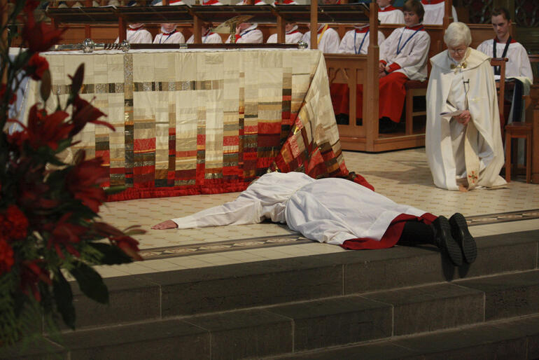 Bishop Victoria Matthews prostrates herself before the altar of ChristChurch Cathedral.