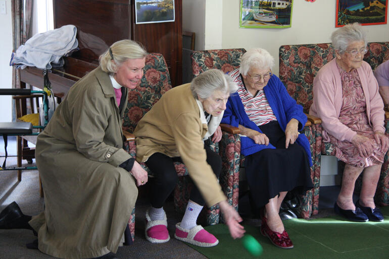 Bishop Victoria watches while a spirited game of indoor bowls is in progress. Bishop Victoria watches while a spirited game of indoor bowls is in progress.