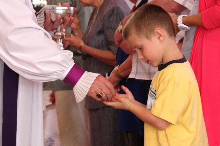 A young boy ponders the meaning of the Eucharist.