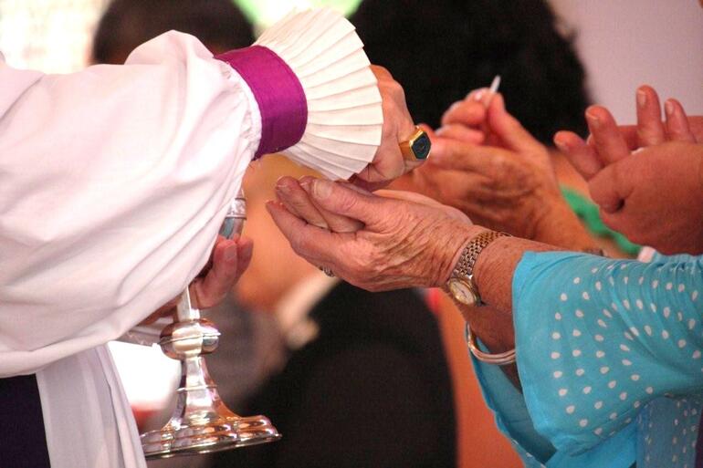 The bishop serves communion.