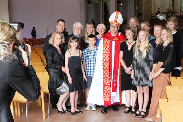 Bishop Jim with his extended family. Jane is beside him, next to their daughter Sophie. Samuel is at the back, far right. Bishop Jim with his extended family. Jane is beside him, next to their daughter Sophie. Samuel is at the back, far right.