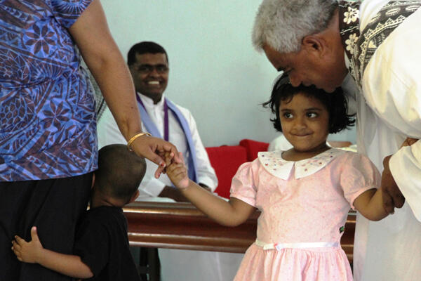 Sharon is a bashful birthday girl - and she's being encouraged here by Fr Ben Tapelu.