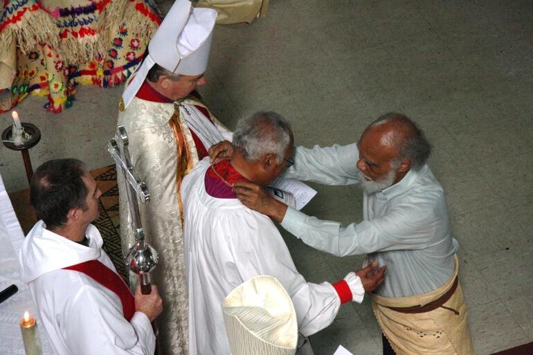 Dr Sitiveni Halapua drapes the pectoral cross around his brother's neck. Dr Sitiveni Halapua drapes the pectoral cross around his brother's neck.