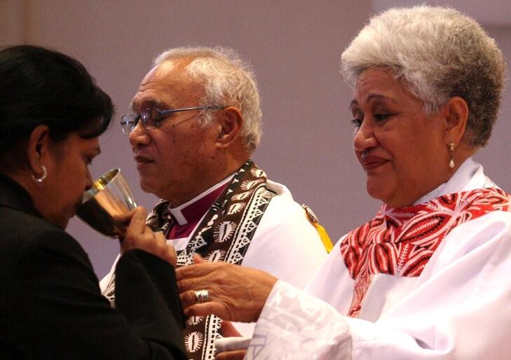 The Rev Tai offers the chalice.