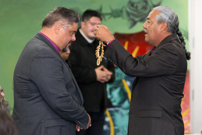 Indigenous church leader Canon Andy Orozco offers a gift of recognition to Archbishop Don.