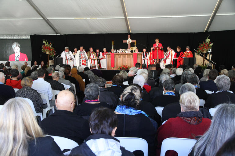 Dr Doris Kaua reads a lesson as the crowd of worshippers listen. Dr Doris Kaua reads a lesson as the crowd of worshippers listen.