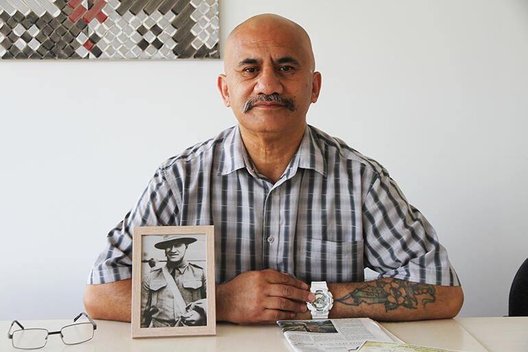 Colenso Eramiha, who is Kaiwhakamana at the John Kinder Theological Library in Auckland, with a portrait of his Uncle Sonny at his elbow.