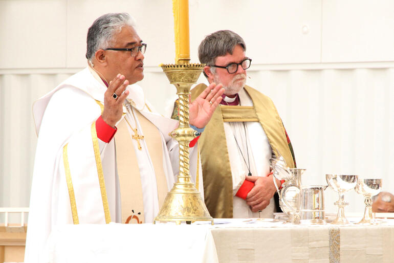 Bishop of Polynesia, Archbishop Sione Uluilakepa prays at the altar.