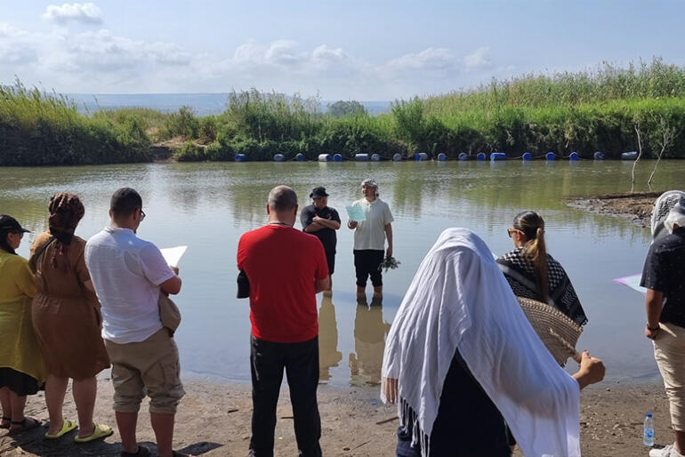 Rev Zhane Tahau Whelan leads karakia with Te Waipounamu and Te Rau College pilgrims at the River Jordan.