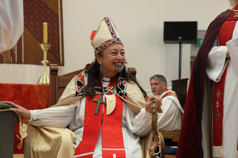 Bishop Susan holds her hand on the pounamu mauri stone as she pledges her commitment to spiritual leadership of Te Hāhi Mihinare in Te Waipounamu.