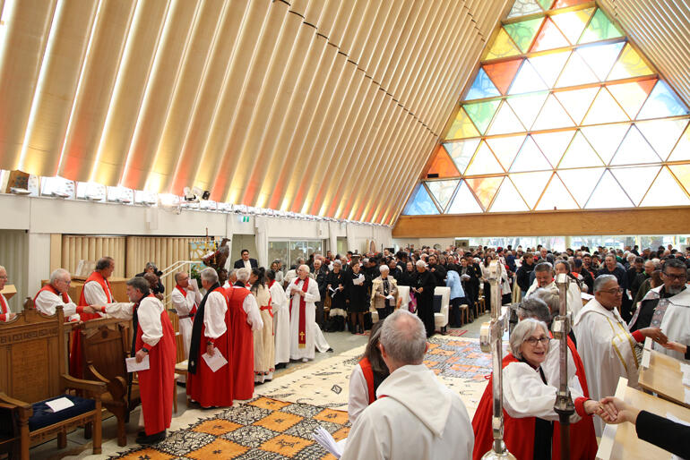 Worshippers at Bishop Susan's ordination share the peace.