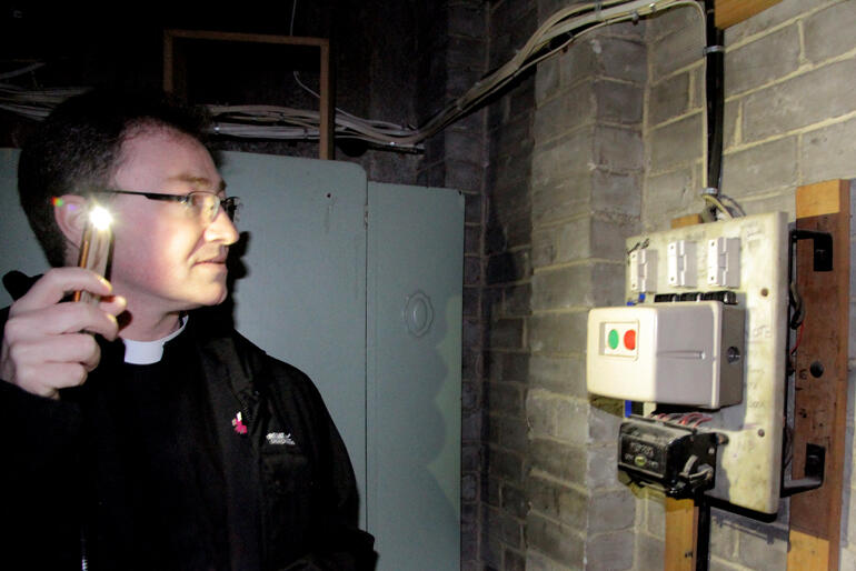 Dean Tony Curtis checks out some of the water damaged electrical boards in the blower room of the Cathedral's pipe organ.