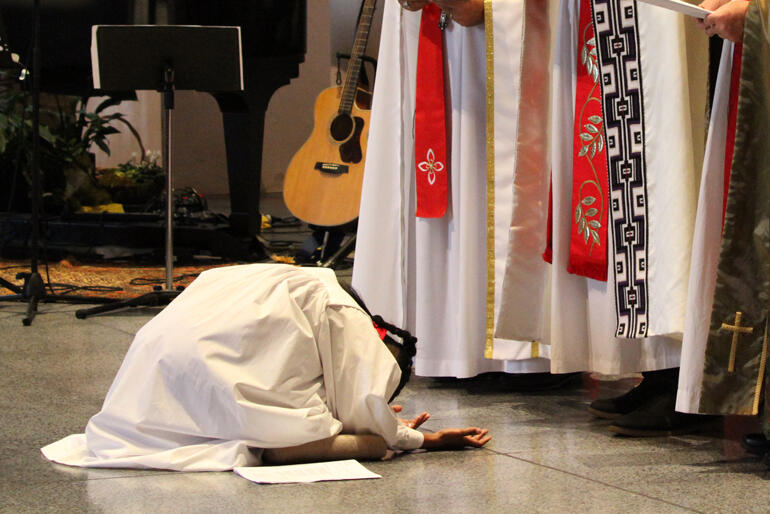 Anashuya Fletcher waits with outstretched hands as the choirs sings "Come Holy Ghost, our souls inspire."