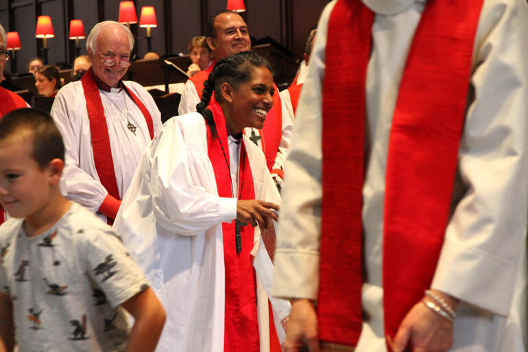 Bishop Anashuya greets children bearing gifts for her.