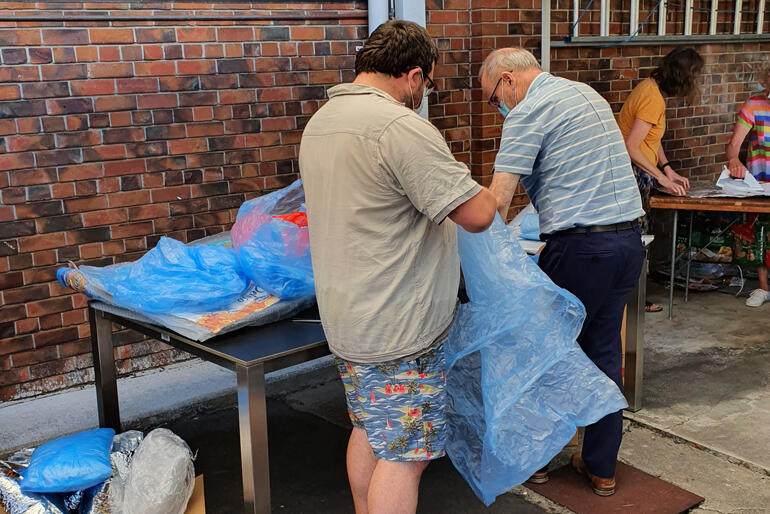 Fusion Friday: members of St Philip's Anglican Church process chip packets and plastic sheets into survival bags and ground sheets. Fusion Friday: members of St Philip's Anglican Church process chip packets and plastic sheets into survival bags and ground sheets.