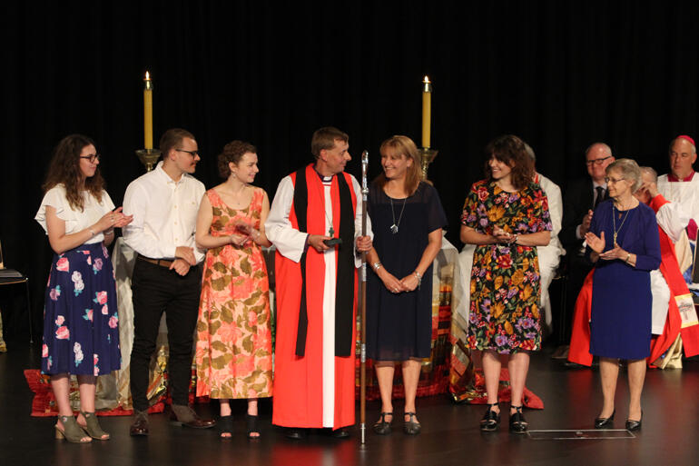 Bishop Peter's family applaud alongside Bev Goodall, widow of Bishop Maurice Goodall, whose pectoral cross she gifted to Peter. Bishop Peter's family applaud alongside Bev Goodall, widow of Bishop Maurice Goodall, whose pectoral cross she gifted to Peter.