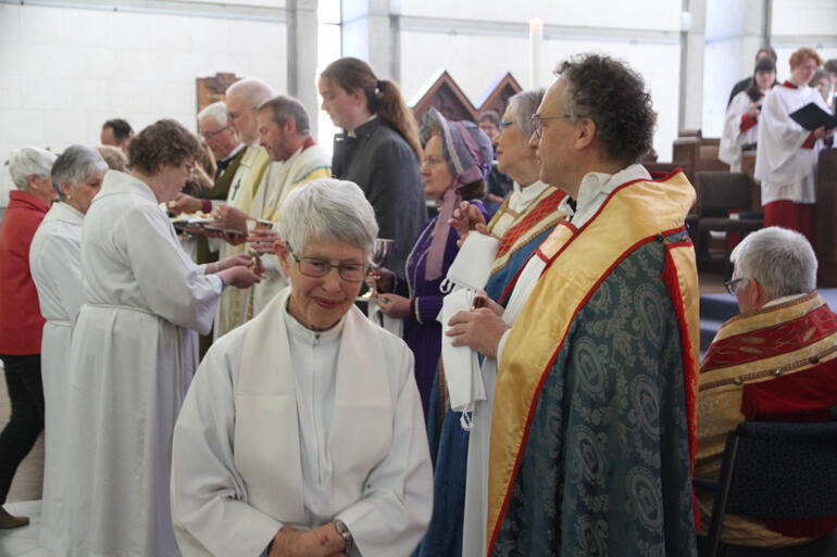 Rev Cushla McMillan smiles after receiving the Eucharist and anointing during the 150th festival service.