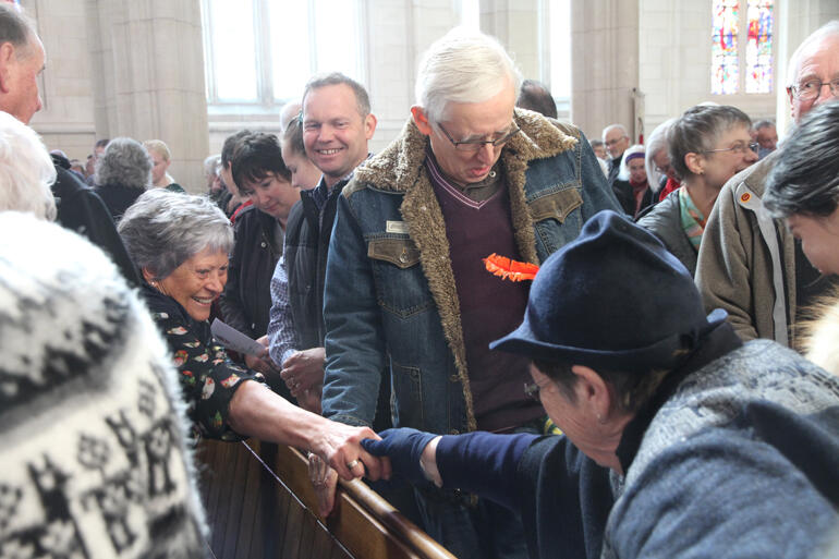 Worshippers pass the peace at St Paul's Cathedral Dunedin on Sunday 15 September. 