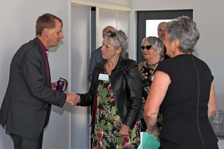 Bishop Peter Carrell shakes hands with Christchurch Methodist Mission Chair Pam Sharpe, as CMM Director Jill Hawkey (right) looks on.
