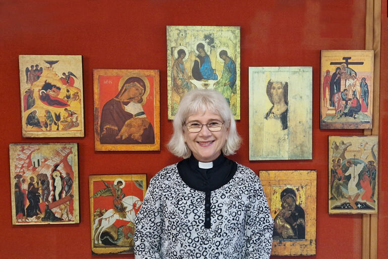 Rev Dr Jacky Sewell stands before a makeshift iconostasis with Rublev's Christ to her left and his Trinity behind her.