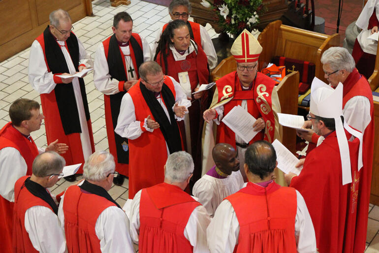 Bishops encircle Steve as they wait on the Holy Spirit.