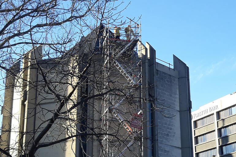 Members of the Dunedin City central station fire crew inspect a burnt out section of roof on the east end apse at St Paul's Cathedral Dunedin. Members of the Dunedin City central station fire crew inspect a burnt out section of roof on the east end apse at St Paul's Cathedral Dunedin.