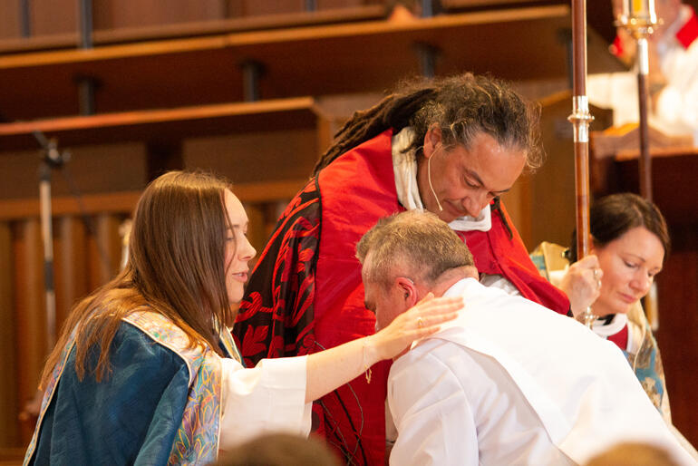 Bishop Eleanor Sanderson and Bishop Justin Duckworth pray for newly deaconed Rev Michael Hartfield.