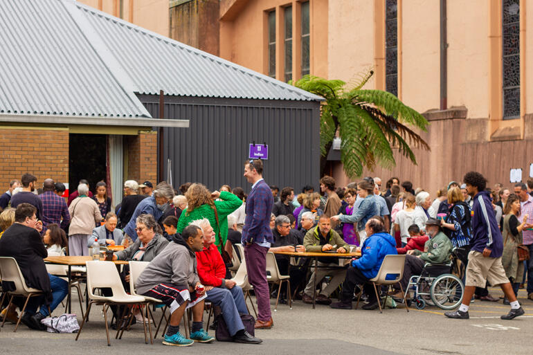 People eat together at the festival of food outside St Paul's Cathedral during the Wellington Diocesan day of Thanksgiving and Celebration.