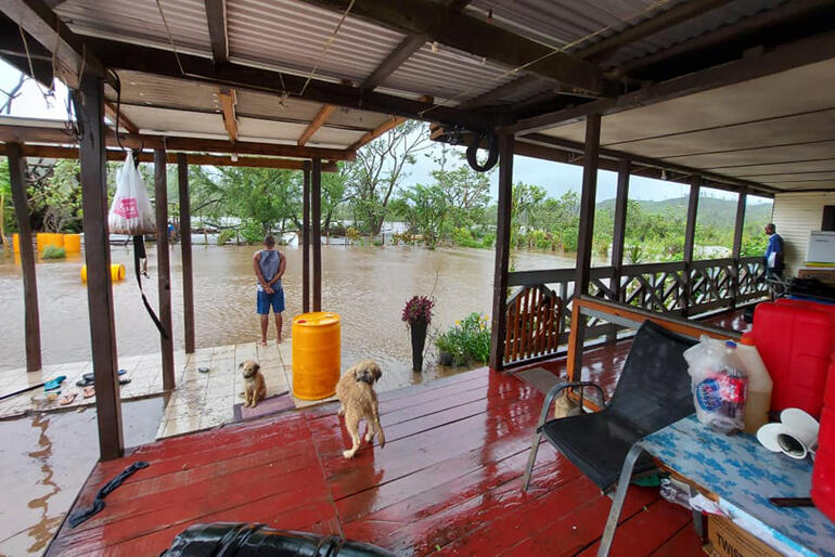 Bishop Henry Bull stands outside his floodwater surrounded house in Vanua Levu overlooking the yard where a large community garden stood last week.