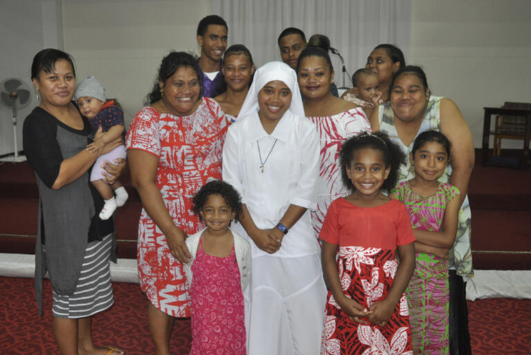 New Moana Community of St Clare Novice Miliva stands with her proud family supporters at her clothing service in St Christopher's Church, Naulu, Fiji.