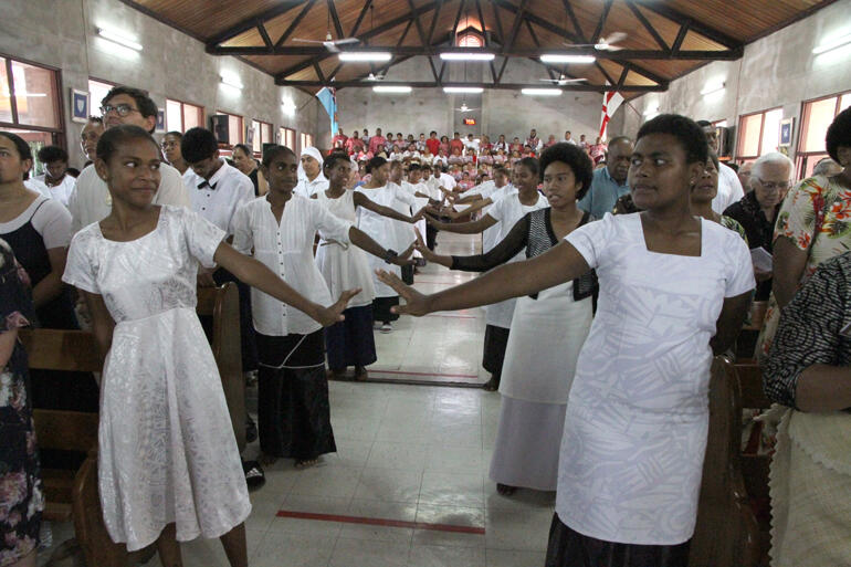 Children from St Christopher's Home perform an action song to accompany the sung Lord's Prayer.