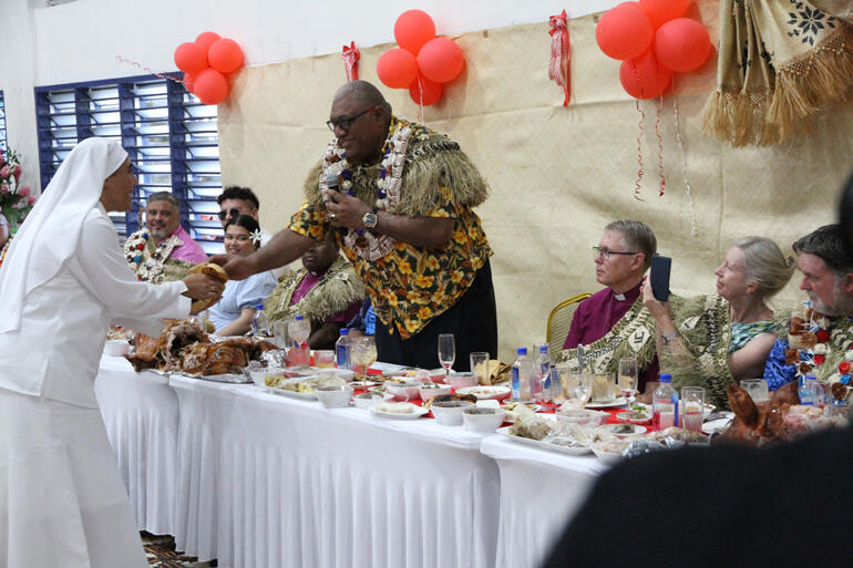 Fijian President Ratu Wiliame Katonivere returns a ceremonial cash gift to Sister Kalolaini Tuineau for St Christopher's Home.