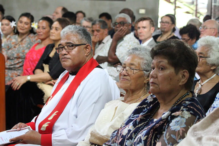 Fr Sione Uluilakepa listens while his mother Melesa Uluilakepa sits in the family pew by his side.