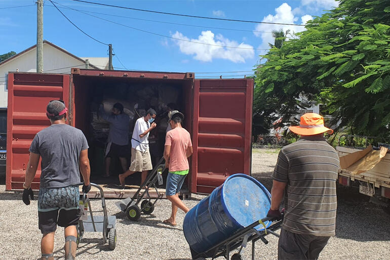 Tonga 2022: People in Tongatapu unload material from one of the prepositioned containers that play a lifesaving role after disasters. Tonga 2022: People in Tongatapu unload material from one of the prepositioned containers that play a lifesaving role after disasters.