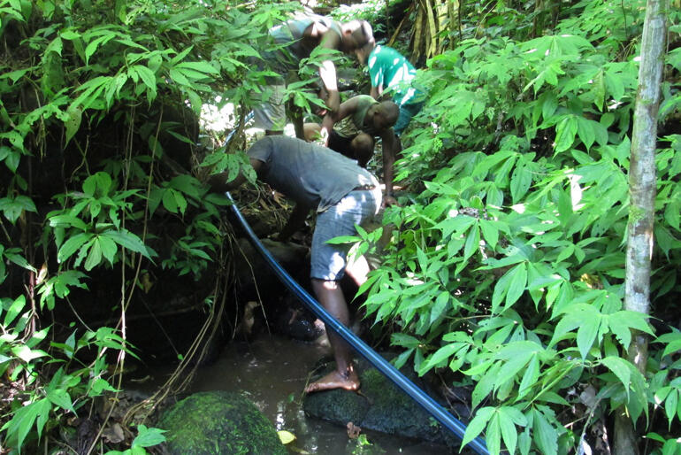 Anglican community members in the Solomon Islands maintain a water system. The 2021 Lenten Appeal fundraises for three 10K litre tanks.