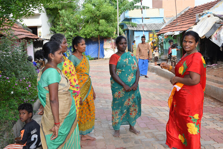 Newly empowered by her sangam, Muneeswari (in red) talks with women in a village street in Tamil Nadu, India. Photo:WDRC Newly empowered by her sangam, Muneeswari (in red) talks with women in a village street in Tamil Nadu, India. Photo:WDRC